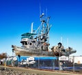 Huge aluminum fishing vessel blocked up on asphalt