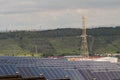 Huge area with a Transmission tower and large solar panels with green hills behind Royalty Free Stock Photo