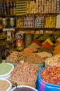Huge barrels of colorful herbs and spices stacked in little shop in souks of Fez, Morocco