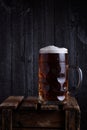 Huge beer mug on vintage wooden crate with dark wooden background Royalty Free Stock Photo