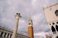 A huge bell tower made of red brick in Piazza San Marco - Campanile of St. Mark`s Cathedral in Venice, Italy. Against Royalty Free Stock Photo