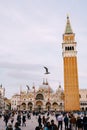 A huge bell tower made of red brick in Piazza San Marco - Campanile of St. Mark`s Cathedral in Venice, Italy. Two Royalty Free Stock Photo