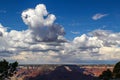 Huge billowing clouds in a blue sky above the Grand Canyon with dramatic shadows