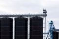 A huge, blackm steel grain silo standing in a field.