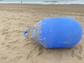 Huge blue buoy abandoned in the beach sand Royalty Free Stock Photo