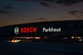 Huge Bosch letters at the Stuttgart Airport parking garage with long exposure of highway A8 at dusk. Bosch is a German Royalty Free Stock Photo