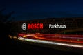 Huge Bosch letters at the Stuttgart Airport parking garage with long exposure of highway A8 at dusk. Bosch is a German Royalty Free Stock Photo