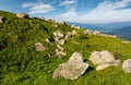 Huge boulders on a grassy slope in mountains Royalty Free Stock Photo