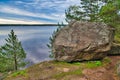Huge boulders stones covered with moss and pine forest near beatiful fresh blue lake, Park Mon Repos, Vyborg, Russia Royalty Free Stock Photo