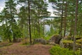 Huge boulders stones covered with moss and pine forest near beatiful fresh blue lake, Park Mon Repos, Vyborg, Russia Royalty Free Stock Photo