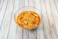 Huge bowl of chickpea hummus with olive oil, paprika and pieces of tasty raw almonds on colorful wooden background