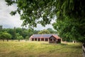 A huge brick barn with solar panels on the roof. Horse stud in Florianka. Beautiful rural landscape. The horse run in the