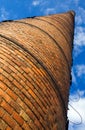 Huge brick chimney under blue sky