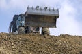 Huge bucket of an escalator against the background of the sky with clouds. Global construction. Mining