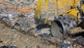 Huge bulldozer at a landfill or dump cleaning household garbage, ecology concept