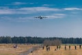 Huge cargo plane is approaching the runway and is about to land on an airport in Ljubljana, Slovenia. Crowd of people observing Royalty Free Stock Photo