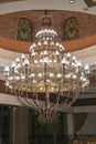 Huge chandelier in the hall. Chandelier on decoarted ceiling of a ballroom. vertical photo. Royalty Free Stock Photo