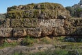 Huge cobblestones covered with moss. The ruins of the old wall of the ancient temple