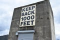 Huge concrete building with a big Keep back 1000 feet text on it