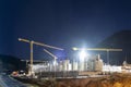 Huge concrete construction site at night with four stationary tower cranes Royalty Free Stock Photo
