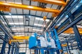 A huge crane lifting heavy machinery indoors