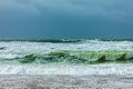 Huge crashing waves during a massive storm under a dark sky