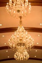Huge crystal glass chandeliers hanging on ballroom dance in wedding ceremony date,decorated by victorian style. Royalty Free Stock Photo