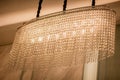 Huge crystal glass chandeliers hanging on ballroom dance in wedding ceremony date. Royalty Free Stock Photo