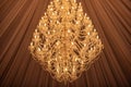 A huge crystal gold chandelier with candles, against Glamour brown lines background