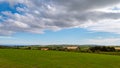 A huge cumulus cloud in the sky over the Irish countryside in summer. Irish landscape. Green farm fields. Green grass field under Royalty Free Stock Photo