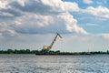 Huge digger in quarry for sand extraction mining in lake