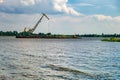 Huge digger in quarry for sand extraction mining in lake