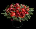 Huge edible fruit bouquet consisting of pomegranates, apples, grapes, rose flowers and fir twigs on black background