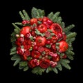 Huge edible fruit bouquet consisting of pomegranates, apples, grapes, rose flowers and fir twigs on black background