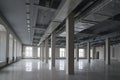 Huge empty open space in the old factory building with rows of columns, large windows and pipes under the ceiling Royalty Free Stock Photo