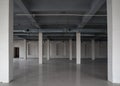 Huge empty storehouse or open space with rows of columns, ceramic floor and pipes under the ceiling