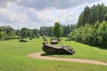 Huge erratic boulders in the megalith park. Big stones lie in the green grass. There are green trees around. Silvarium, a forest p Royalty Free Stock Photo