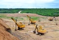 Huge excavators with electric shovel working in the quarry. Big mining trucks transport of minerals in the limestone open-pit