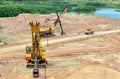 Huge excavators with electric shovel working in the quarry. Big mining trucks transport of minerals in the limestone open-pit Royalty Free Stock Photo