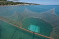 Huge fishing net is pulled up by ropes in a traditional fishing trabucco in Italy