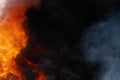 Huge flames of red fire, motion blur clouds of dark smoke covered sky Royalty Free Stock Photo