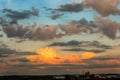 Huge, fluffy clouds, highlighted by the rising sun above buildin Royalty Free Stock Photo