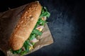 Huge fresh crispy baguette sandwich with meat, prosciutto, cheese, lettuce salad and vegetables Royalty Free Stock Photo