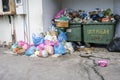 Huge garbage piles next to the dumpster. Overflow garbage