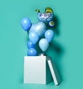 Huge Gift or present box with blue pastel color balloons and latex metallic heart baby carriage on light green blue background Royalty Free Stock Photo