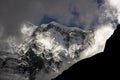 A huge glacier from a very high mountain appears among the clouds in the annapurna of the nepali himalayas