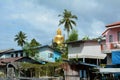 A huge golden Buddha sitting back to the small thai town