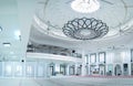 Huge hall of the mosque with modern minimalist chandelier at the center