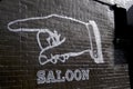 Huge Hand painted on a black wall with the text `Saloon` in beneath