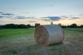 A huge hay bale lying in the meadow and the evening sky Royalty Free Stock Photo